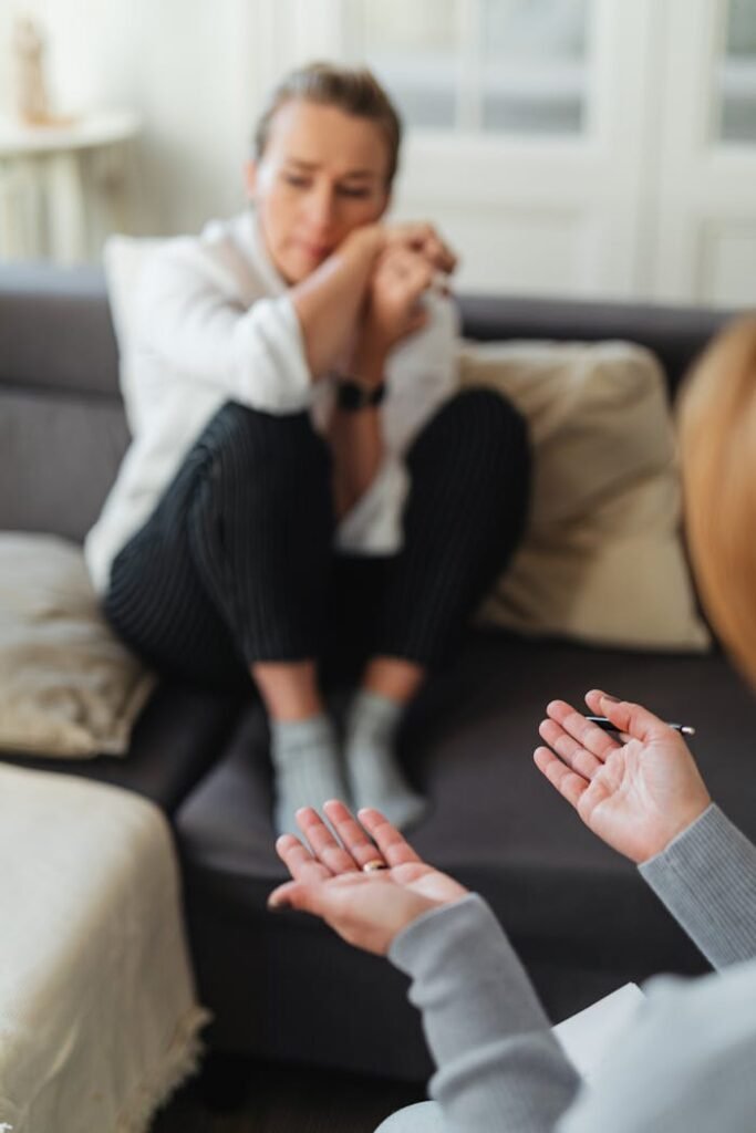 pexels-photo-6255869 A woman in distress during a therapy session, showing emotional support and communication.